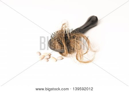 Close-up of hair loss, long hair, alopecia treatment on white background with brush