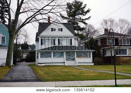 WEQUENTONSING, MICHIGAN / UNITED STATES - DECEMBER 23, 2015: The front porch of a white home, on Beach Drive in Wequetonsing, is protected from the winter weather.