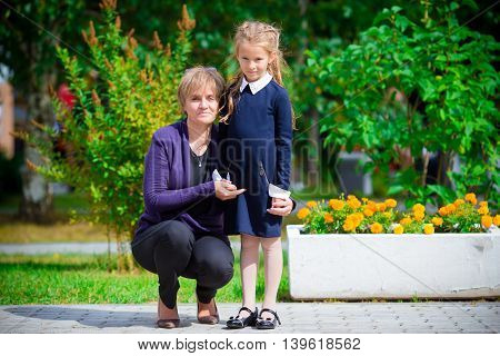 Grandmother brings her little granddaughter to school.