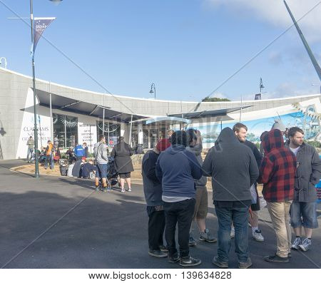 Whangarei, New Zealand - July 16,2017; Pokemon Go craze sweeps the world here Riverside public space Whangarei New Zealand  groups of youth sit around or stand looking at their devices  searching for a Pokemon
