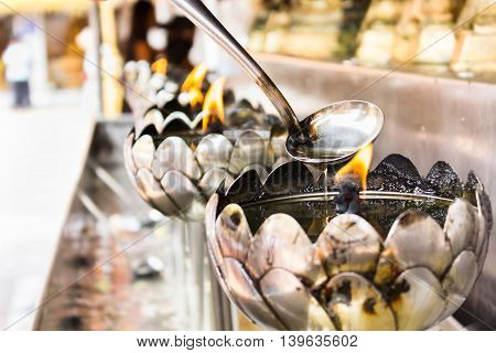 Do merit by filling oil oil lamp in temple