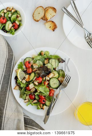 Fresh vegetable salad on a white table. Top view.