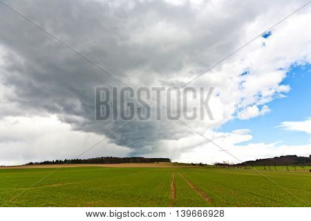 dark clouds over fields in springtime in rural landscape