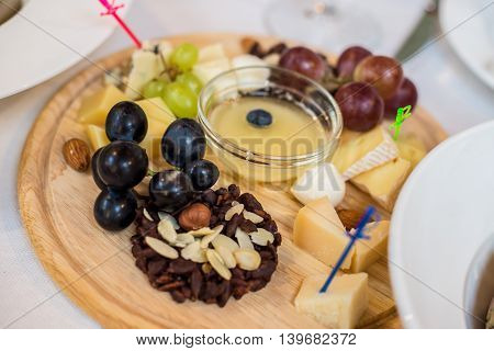 Cheese plate with variety of appetizers on table