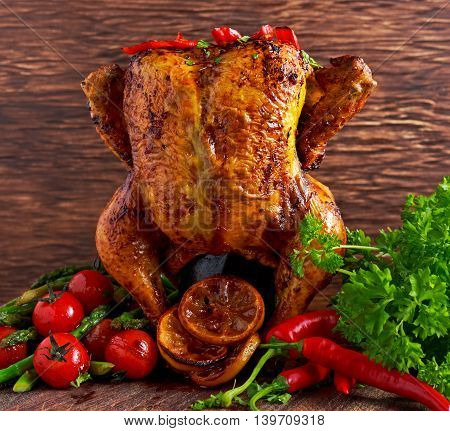Gourmet Roast Whole organic chicken on cider Can With Asparagus, glazed Cherry Tomatoes, Herb and Spices, Served on Top of a Wooden Table