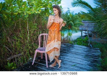 Photo young girl enjoying tropical fruits in jungle house. Smiling woman spending chill time outdoor summer. Horizontal picture, Bali island