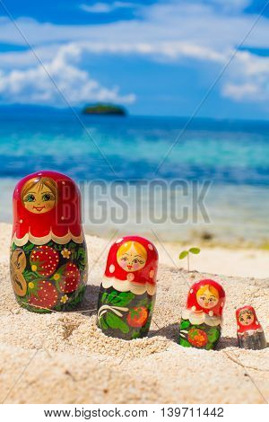 Photo Rows Puzzle Russian Dolls Matrioshka Souvenir Untouched Tropical Beach in Bali Island. Vertical Picture. Blurred Background. Closeup
