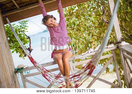 Photo young sexy girl relaxing on beach in Bungalow. Smiling woman spending chill time outdoor summer. Caribbean Ocean Vacations. Horizontal, blurred background