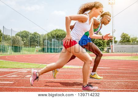 atheletes running at the stadium on runners track