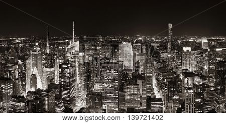 New York City midtown skyline panorama with skyscrapers and urban cityscape at night.
