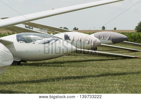 gliders at green airfield with blue sky