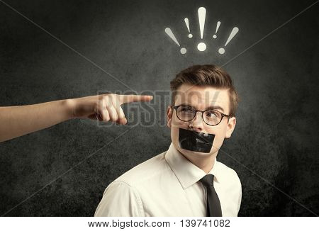Caucasian hand pointing at employee in business suit, with drawn exclamation marks above his head