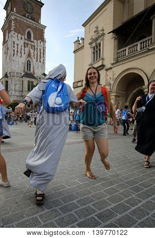 CRACOW POLAND - JULY 24 2016: Pilgrims of World Youth Day sing and dance on the Main Square in Cracow. Poland