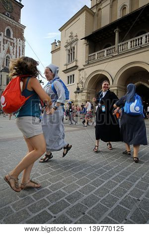 CRACOW POLAND - JULY 24 2016: Pilgrims of World Youth Day sing and dance on the Main Square in Cracow. Poland