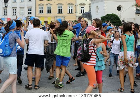 CRACOW POLAND - JULY 24 2016: Pilgrims of World Youth Day sing and dance on the Main Square in Cracow. Poland