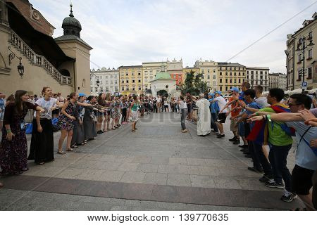 CRACOW POLAND - JULY 24 2016: Pilgrims of World Youth Day sing and dance on the Main Square in Cracow. Poland