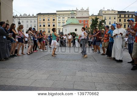 CRACOW POLAND - JULY 24 2016: Pilgrims of World Youth Day sing and dance on the Main Square in Cracow. Poland