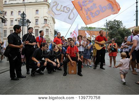 CRACOW POLAND - JULY 24 2016: Pilgrims of World Youth Day sing and dance on the Main Square in Cracow. Poland