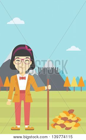 An asian young woman raking autumn leaves. Woman with rake standing near tree and heap of autumn leaves. Woman tidying autumn leaves in garden. Vector flat design illustration. Vertical layout.
