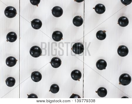 Fresh black currants on white wooden background. blackcurrants pattern for wallpaper. Flay lay or top view