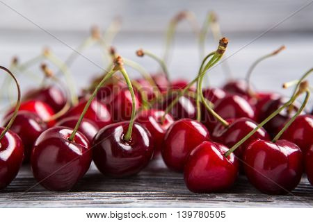 Lots of cherries. Clean berries on wooden surface. High amount of vitamin A. Reduce level of cholesterol.