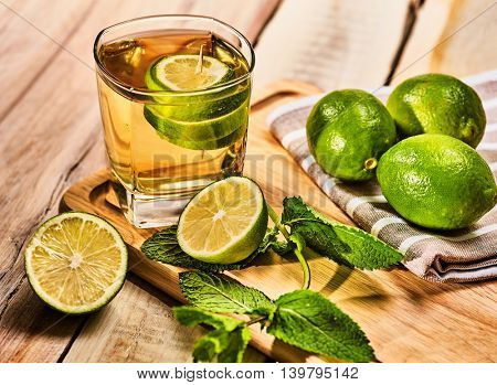 Alcohol drink. On wooden boards glass with alcohol green mohito drink. A mint drink number two hundred fifty six mojito cocktail with half lime and napkin. Top view. Wooden background.Country life.