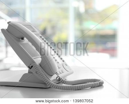 Modern office IP telephone set on light blurred background