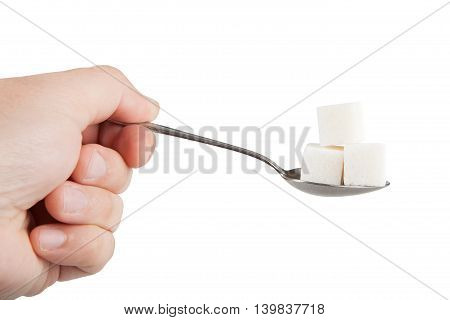hand holding a spoon in which sugar cubes. isolated on white background.