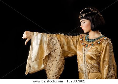 Thumbs down dislike gesture. Glamorous closeup portrait of beautiful sexy stylish brunette young woman model with bright makeup. Cleopatra