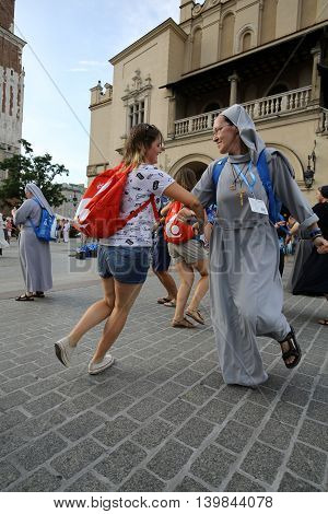 CRACOW POLAND - JULY 24 2016: Pilgrims of World Youth Day sing and dance on the Main Square in Cracow. Poland