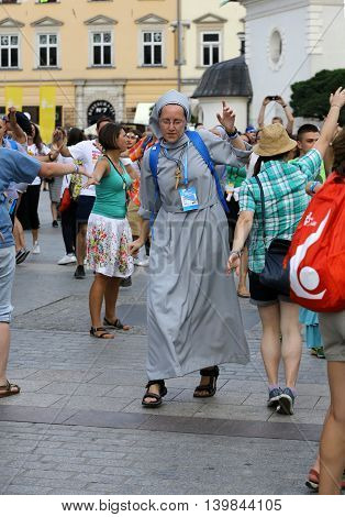 CRACOW POLAND - JULY 24 2016: Pilgrims of World Youth Day sing and dance on the Main Square in Cracow. Poland