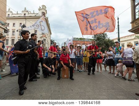 CRACOW POLAND - JULY 24 2016: Pilgrims of World Youth Day sing and dance on the Main Square in Cracow. Poland