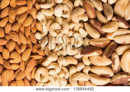 Almonds Cashew and Para Nuts over a wooden table