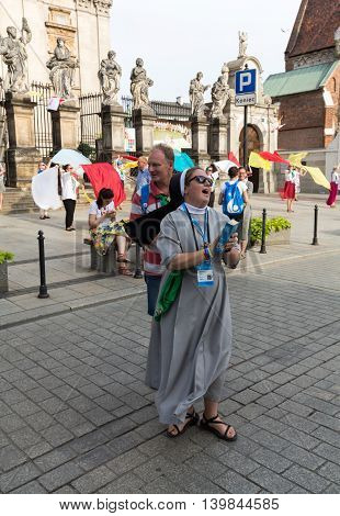CRACOW POLAND - JULY 24 2016: Pilgrims of World Youth Day sing and dance on the St. Maria Magdalena Square in Cracow. Poland