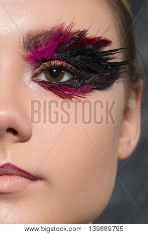 beauty creative makeup with feathers on eyes macro closeup