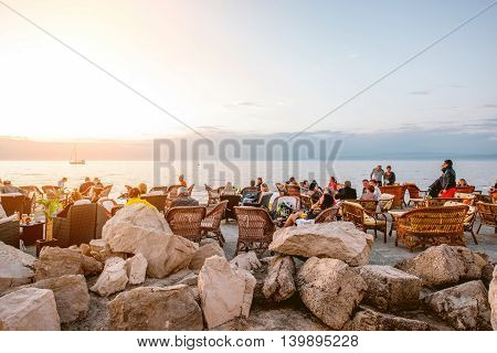 Piran, Slovenia - May 7, 2016: Crowded coastline with people sit at the cafe in Piran town. Piran is one of Slovenia's major tourist attractions.