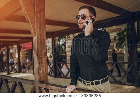 A guy in a nice town, walking, listening to music and taking pictures themselves on the phone
