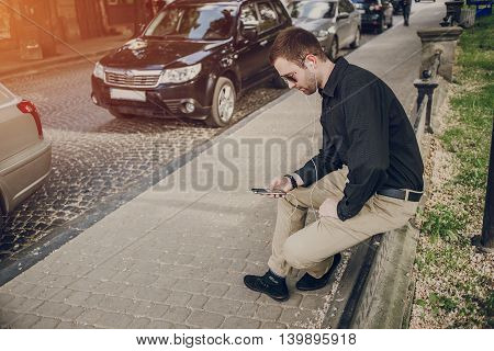 A guy in a nice town, walking, listening to music and taking pictures themselves on the phone