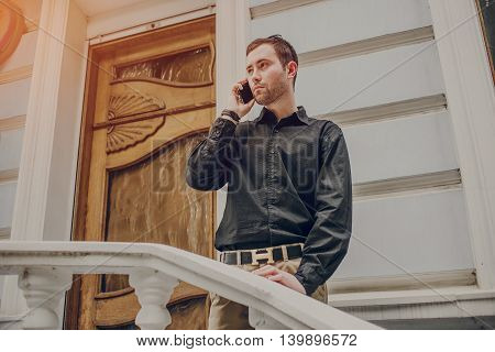 A guy in a nice town, walking, listening to music and taking pictures themselves on the phone