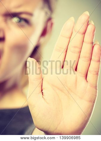 Prohibition symbol. Serious female shows stop sign talk to hand gesture. Angry full of negative emotions woman with hand palm stopping.