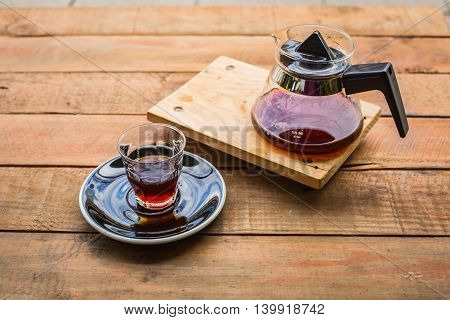 hot coffee cup and pot on wood table in coffee shop.