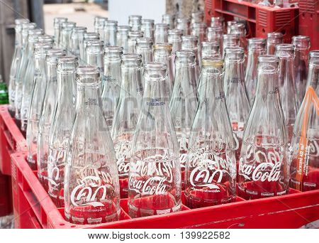 BANGKOK, THAILAND - JUNE 25: Empty recycle bottles of Coca Cola in red plastic box on June 25, 2016 in Bangkok, Thailand. Coca Cola drinks are produced and manufactured by The Coca-Cola Company