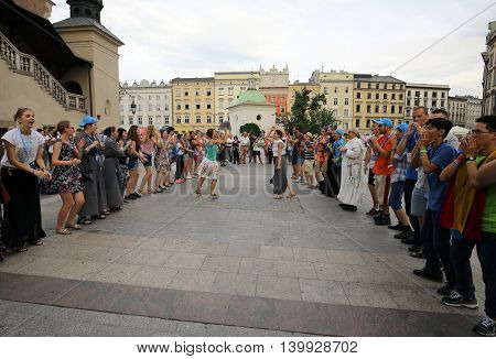 CRACOW POLAND - JULY 24 2016: Pilgrims of World Youth Day sing and dance on the Main Square in Cracow. Poland