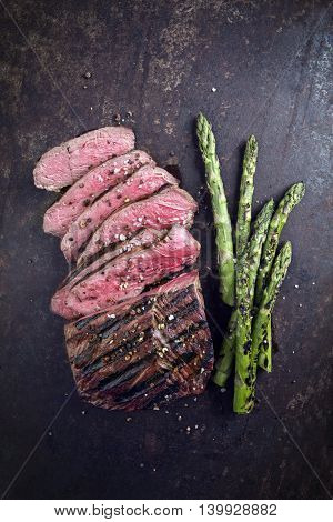 Barbecue Point Steak with green Asparagus on old Sheet