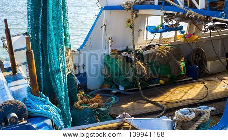 fishing boats anchored in the harbor. Carefully positioned nets and other fishing gear at sea