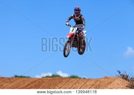 Wingate, Israel - July 23, 2016: Motocross rider and bike clearing a tabletop jump during the final heat of the race.