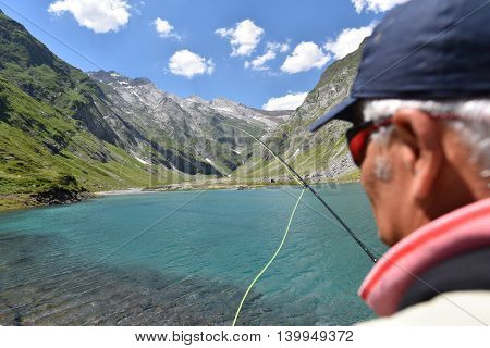 Flyfisherman fishing in mountain lake
