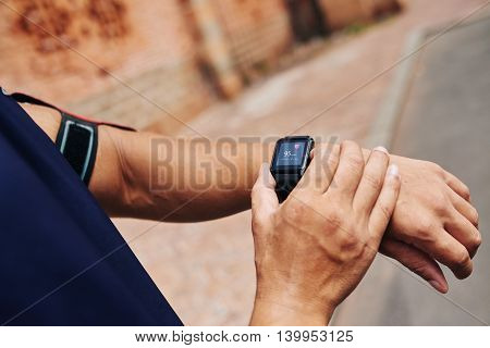 Cloe-up image of sportsman checking his pulse on smart watch