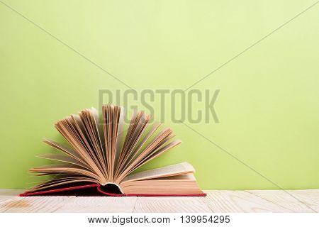 Open book on green wooden bavkground. Education background