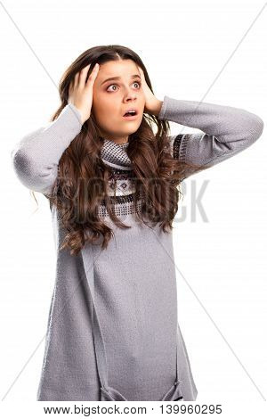 Woman holding head by hands. Young lady with shocked face. Truth is terrifying. You couldn't even imagine.